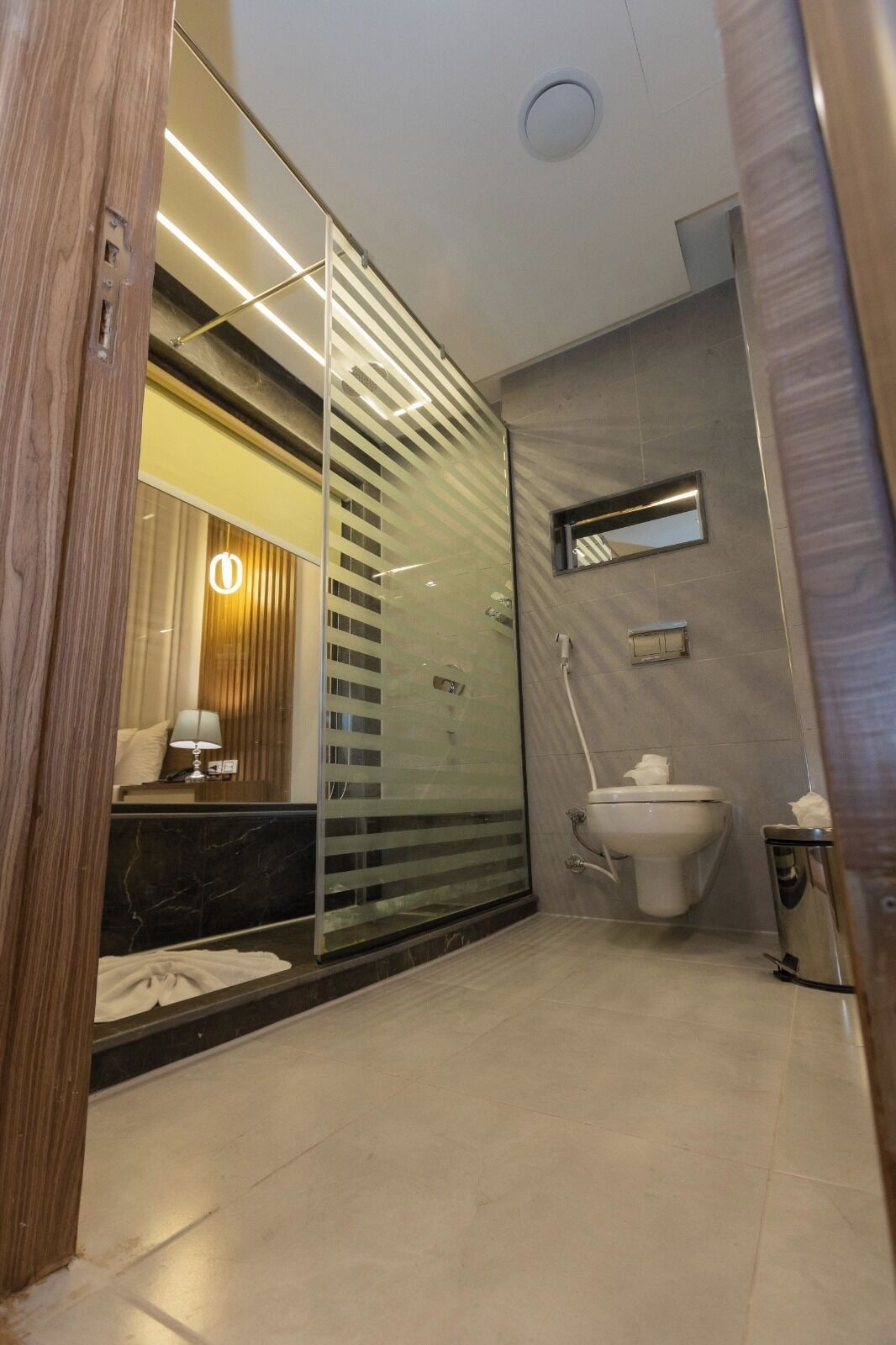 A modern bathroom with a glass shower enclosure, a toilet, and a sink.