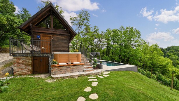 A log cabin with a stone foundation, a wooden deck, a pool, and a stone pathway leading to the entrance. - Cozy home in Gorkovec (Gorkovec)