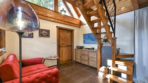 A cozy room with a red sofa, a wooden staircase, a dining area, and a large window. - Cozy home in Gorkovec (Gorkovec)