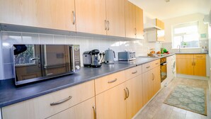 Une cuisine moderne avec des meubles en bois, des appareils en acier inoxydable et un four encastré.