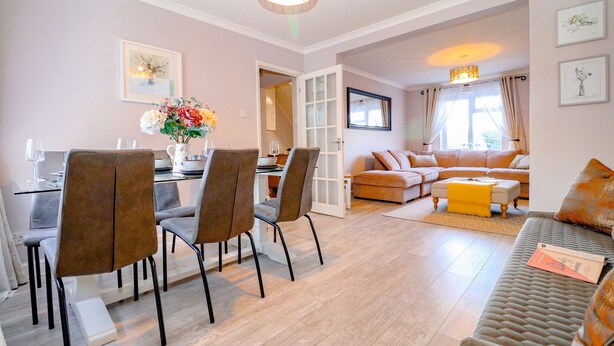 Un salon moderne avec un coin repas, comprenant un canapé, une table basse et une table à manger avec des chaises.