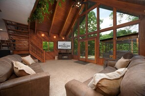 Un salon spacieux doté d’une cheminée, de grandes fenêtres et d’une enseigne indiquant « Dongola Bay Country Home ».