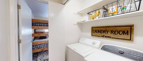 A laundry room with a sign indicating it is for self-service.