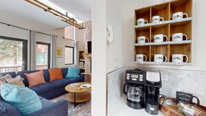 A cozy living room with a sofa, coffee station, and a shelf with numbered mugs. - Close to Lifts | Shuttle Stop | Renovated | Windswept 5 (Angel Fire)