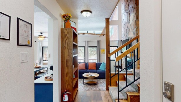 A modern interior with a staircase, a sofa, and a dining area. - Close to Lifts | Shuttle Stop | Renovated | Windswept 5 (Angel Fire)