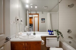 A modern bathroom with a large mirror, a sink, a toilet, and a shower. - Studio | Alpenglow Lodge | Private Balcony w/ Mtn view | Gym | Epic Location (Whistler)