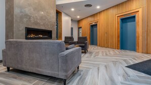 Un vestíbulo moderno con chimenea, zona de estar y paneles de madera.