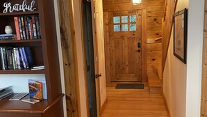 A wooden hallway with a bookshelf labeled "grateful" and a door leading to another room. - Gratitude View - It's cooler in the mountains! (Ararat)