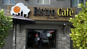 The entrance to Bistro Café with a modern design, including a prominent logo and a sign indicating it has been open since 2011.