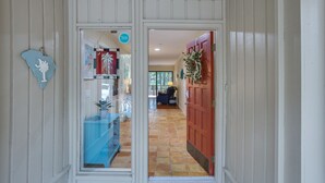 Un pasillo con un armario azul, una puerta roja y una puerta de cristal con un letrero.