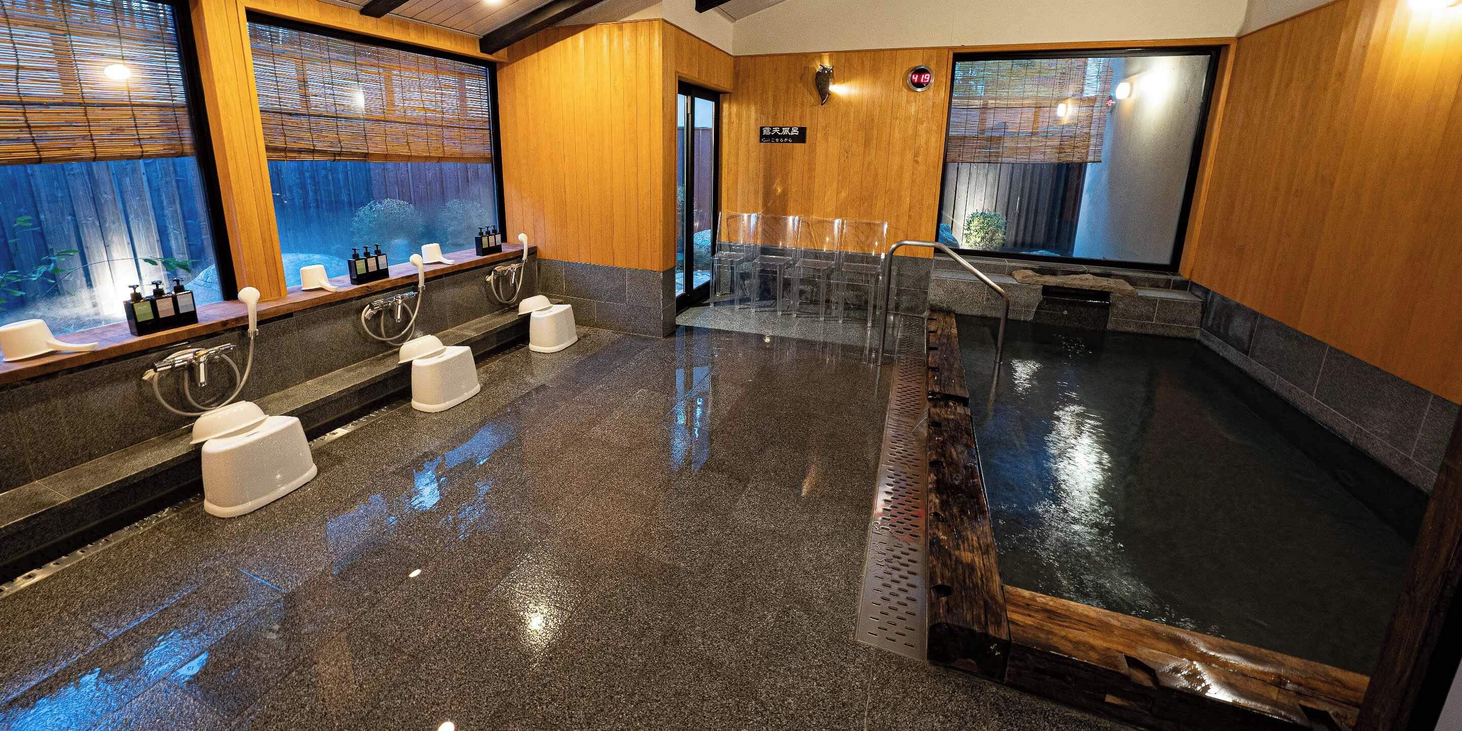 A modern spa area with multiple saunas, wooden walls, and a large window.