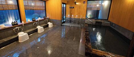 A modern spa area with multiple saunas, wooden walls, and a large window.