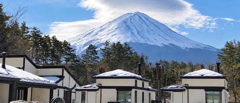 A modern lodge with a view of a snow-capped mountain.