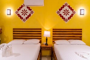 Ein Hotelzimmer mit zwei Betten, Holz-Kopfteilen und dekorativen Wandverkleidungen.