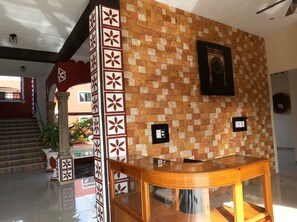 Eine Lobby mit Wandverkleidung, einem Holztisch und einer Treppe.