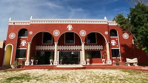 A building with a red facade, white decorative patterns, and multiple arches.