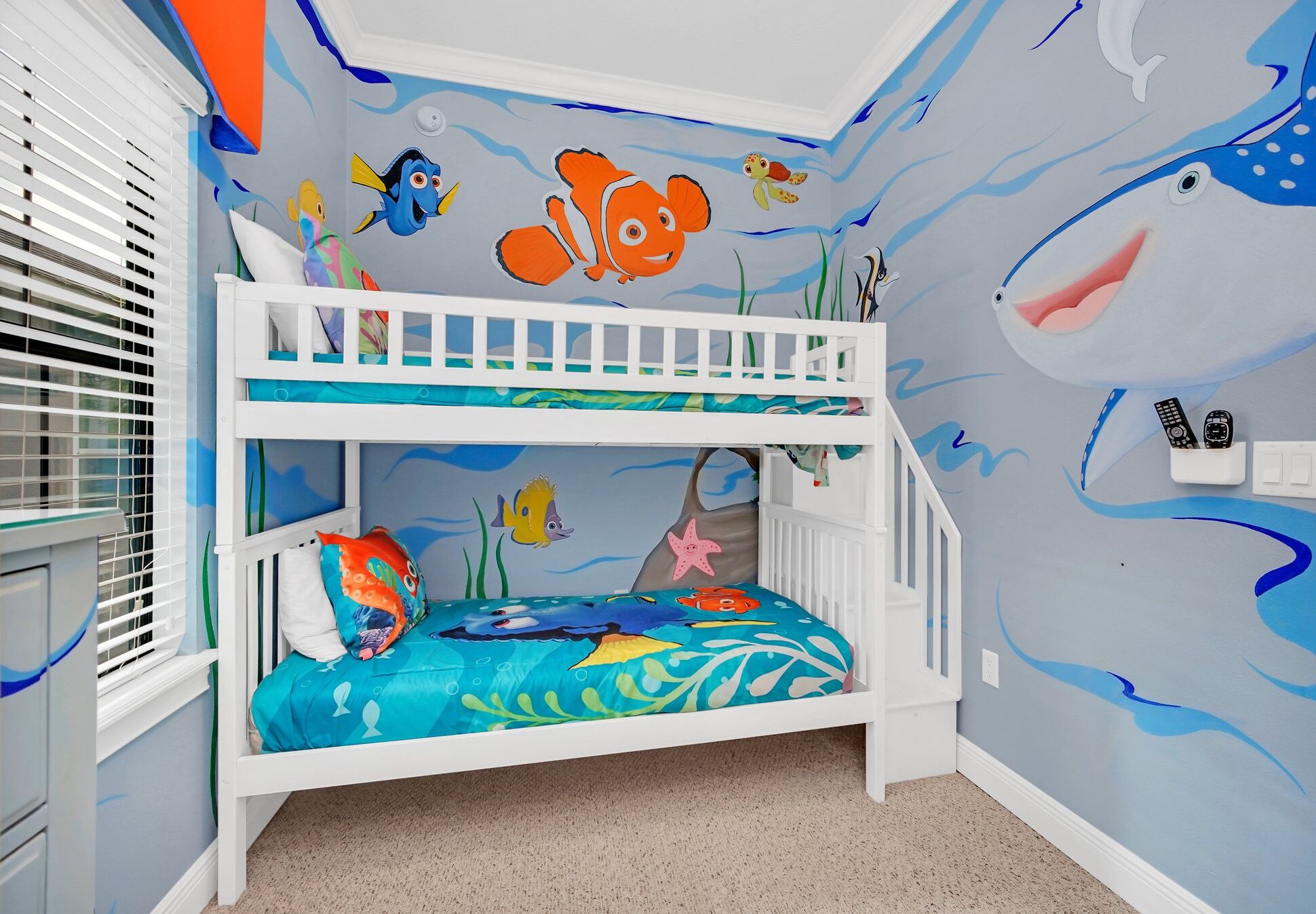 Camera con letto a castello e affresco a tema marino, con pesci e creature marine.