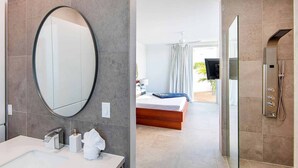 A modern bathroom with a large mirror, a sink, and a shower. - Luxury 3bdr Villa with Private Pool, Oceanview and Hotel Amenities v4 (Providenciales)