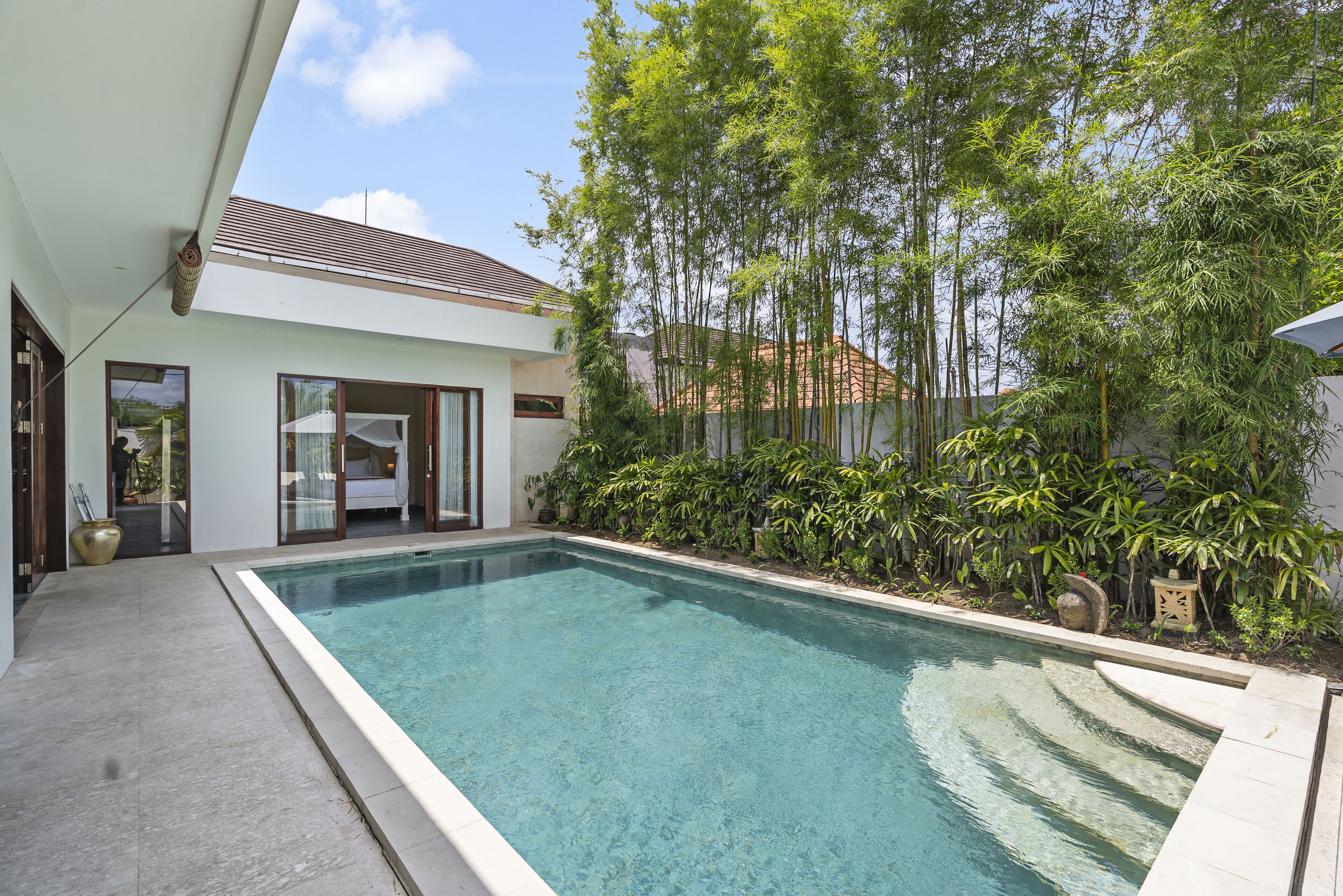 Una casa moderna con piscina, ventanas amplias y jardín.