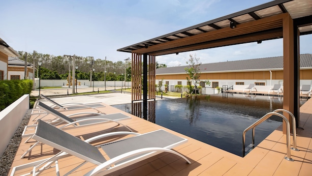 A rooftop pool area with lounge chairs and a pergola. - Japanese Style Villa Sunrise Garden B190 (Thep Krasattri)
