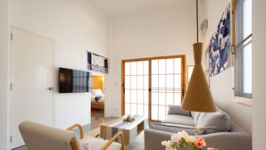 A modern living room with a sofa, a chair, a coffee table, and a TV. - Japanese Style Villa Sunrise Garden B190 (Thep Krasattri)