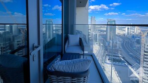 A high-rise balcony with a view of a cityscape, including a highway and several skyscrapers. - Luxury 2bed Balcony City View (Dubai)