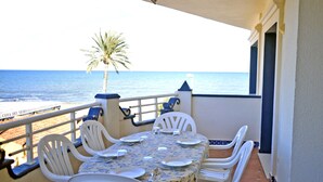 A terrace with a table set for four, white chairs, and a view of the sea. - Anacasa Medina Molins les Marines AP2201 (Denia)