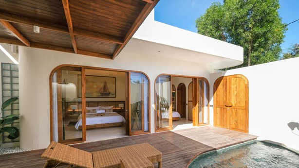 A modern villa with a wooden deck, a swimming pool, and a bedroom with a large bed and a sailboat painting. - Villa Koka Uluwatu (Pecatu)