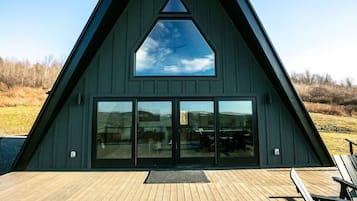 Situated on a wooden deck, this building offers a serene connection to the surrounding landscape and a body of water.