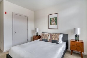 Relax in a serene space with a large bed, bedside tables, and a unique tiger artwork.