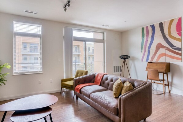 Relax in this stylish living room with a comfortable sofa, a small table, and a floor lamp.