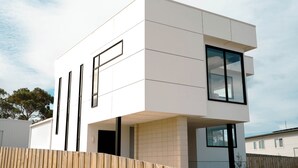A modern, white, two-story building with large windows and a flat roof.