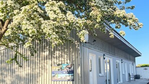 Un bâtiment doté d’une façade en métal ondulé, de fondations en pierre et d’une enseigne.