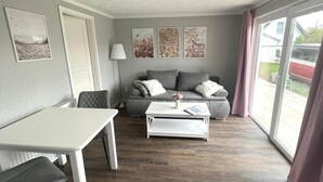 Un salon moderne avec un canapé gris, une table basse blanche et une table à manger.
