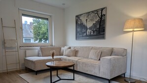 Un salon avec un canapé, une table basse, une lampe et un tableau au mur.