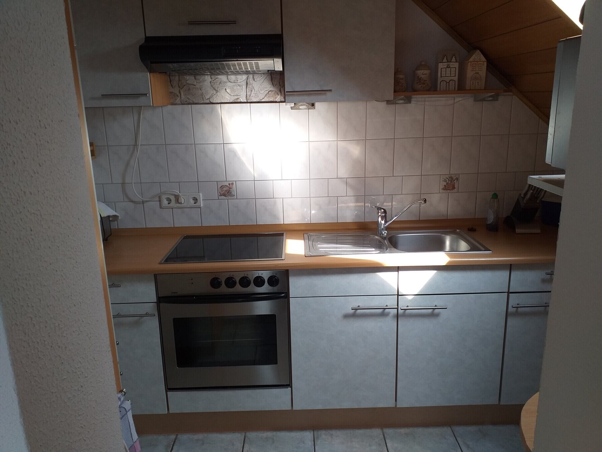 Une cuisine équipée d’une cuisinière, d’un four, d’un évier et d’un plan de travail en bois.