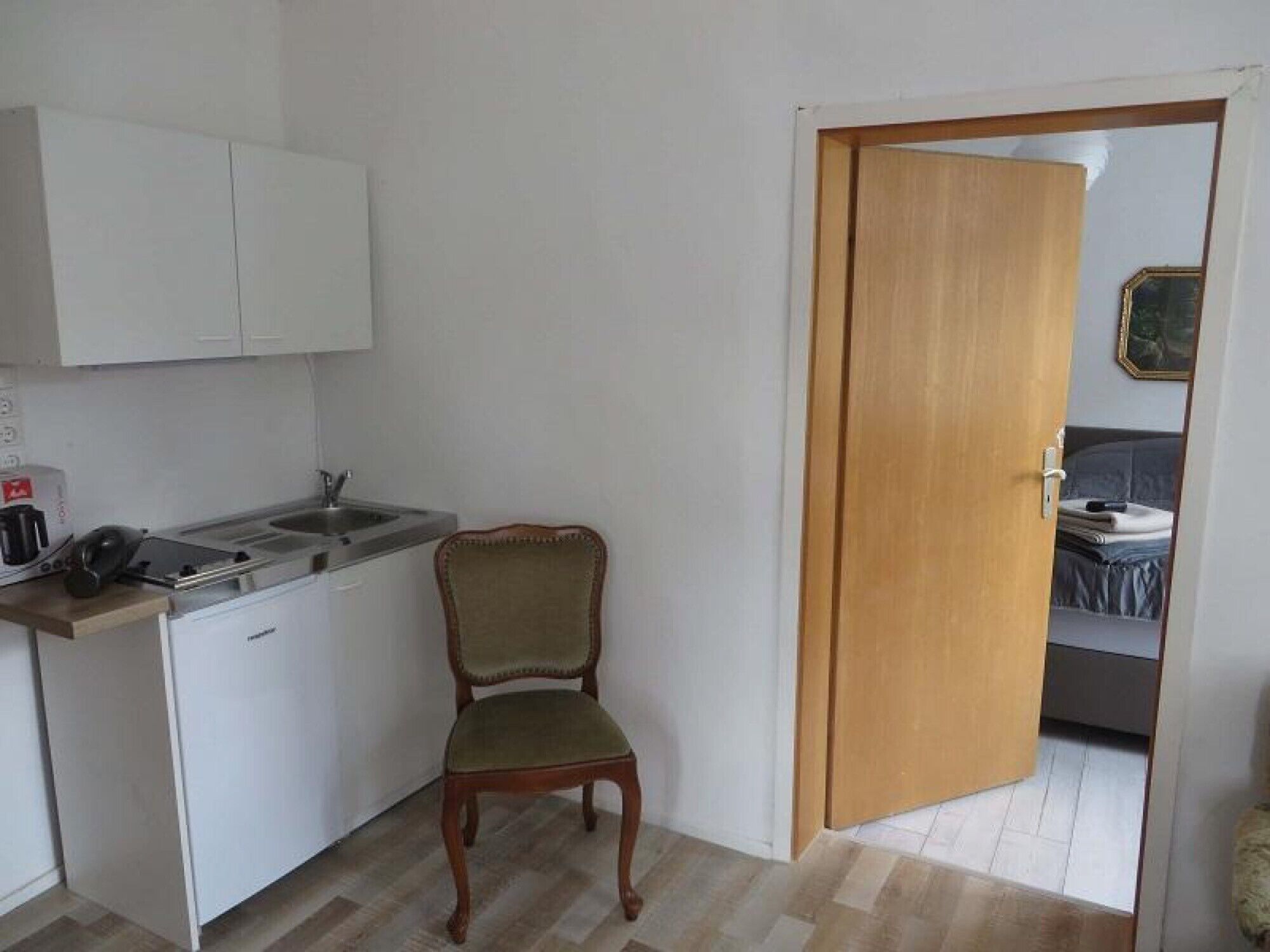 Een koelkast, een kookplaat, een waterkoker, kookgerei, borden en bestek