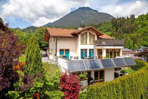 A modern house with a large balcony, solar panels, and a mountain backdrop. - Apartment "Mosers am Sonnenhang" with Mountain View, Private Terrace & Wi-Fi (Jenbach)