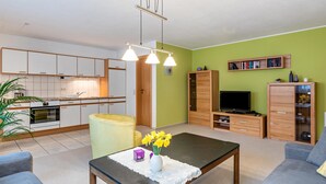 A modern apartment with a kitchen, living room, and dining area.