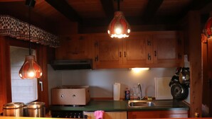 A kitchen with wooden cabinets, stainless steel appliances, and pendant lighting. - Holiday Home 'Landhaus Mit Saunakeller' with Private Terrace, Wi-Fi and Air Conditioning (Bad Wünnenberg)