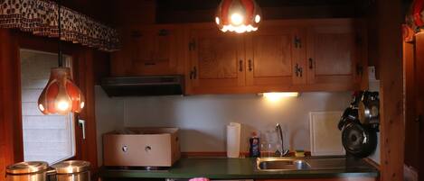 A kitchen with wooden cabinets, stainless steel appliances, and pendant lighting.