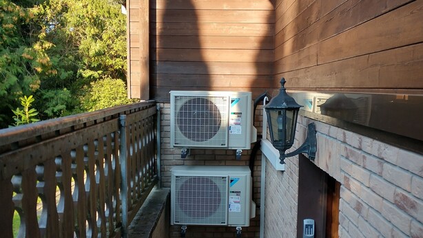 A wooden balcony with two air conditioning units, a metal railing, and a brick floor. - Holiday Home 'Landhaus Mit Saunakeller' with Private Terrace, Wi-Fi and Air Conditioning (Bad Wünnenberg)