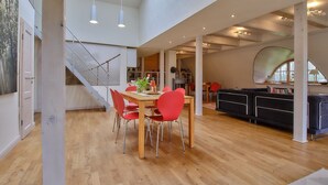 Un ambiente spazioso con zona pranzo, scala e cucina moderna.