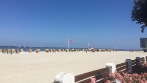 En strand med et træhegn, et flag og en klar himmel.