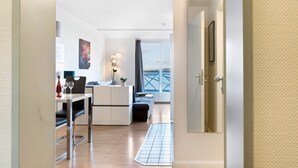 Et moderne interiør med spiseplads, køkken og udsigt gennem en dør.