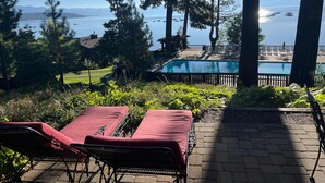 A pool area with lounge chairs and a view of the ocean. - Central Tahoe Retreat | Lake Views + Walk to Shore (Tahoe City)