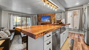 Una cocina moderna con una isla de madera, electrodomésticos de acero inoxidable y un ventanal grande.