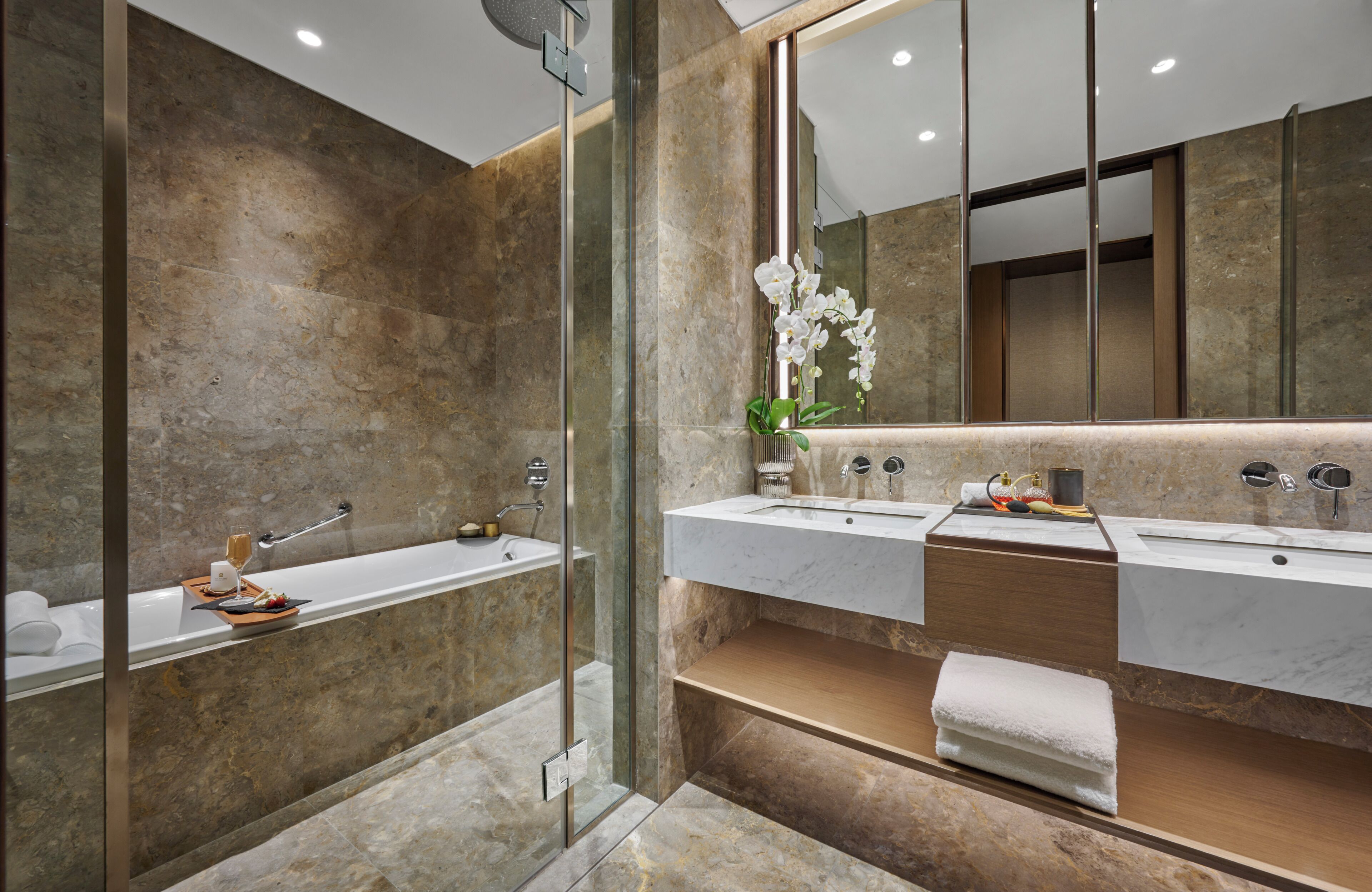 A modern bathroom with a glass-enclosed shower, a double sink vanity, and a large mirror.