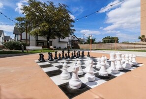Experience the game of strategy in a serene outdoor setting, surrounded by modern architecture and beautifully landscaped surroundings.