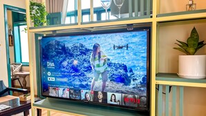 A television mounted on a wall with a screen displaying a movie scene. - Alsahar Hoi An Boutique Villa Apartment (Da Nang)
